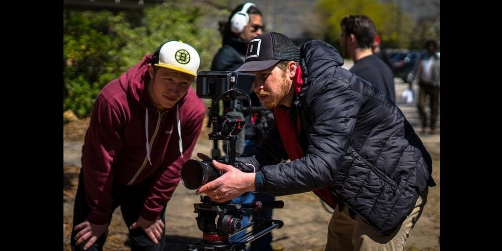 Two people behind a camera getting ready for a shot on location