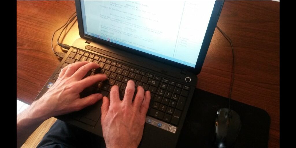 Person writing a screenplay on a laptop