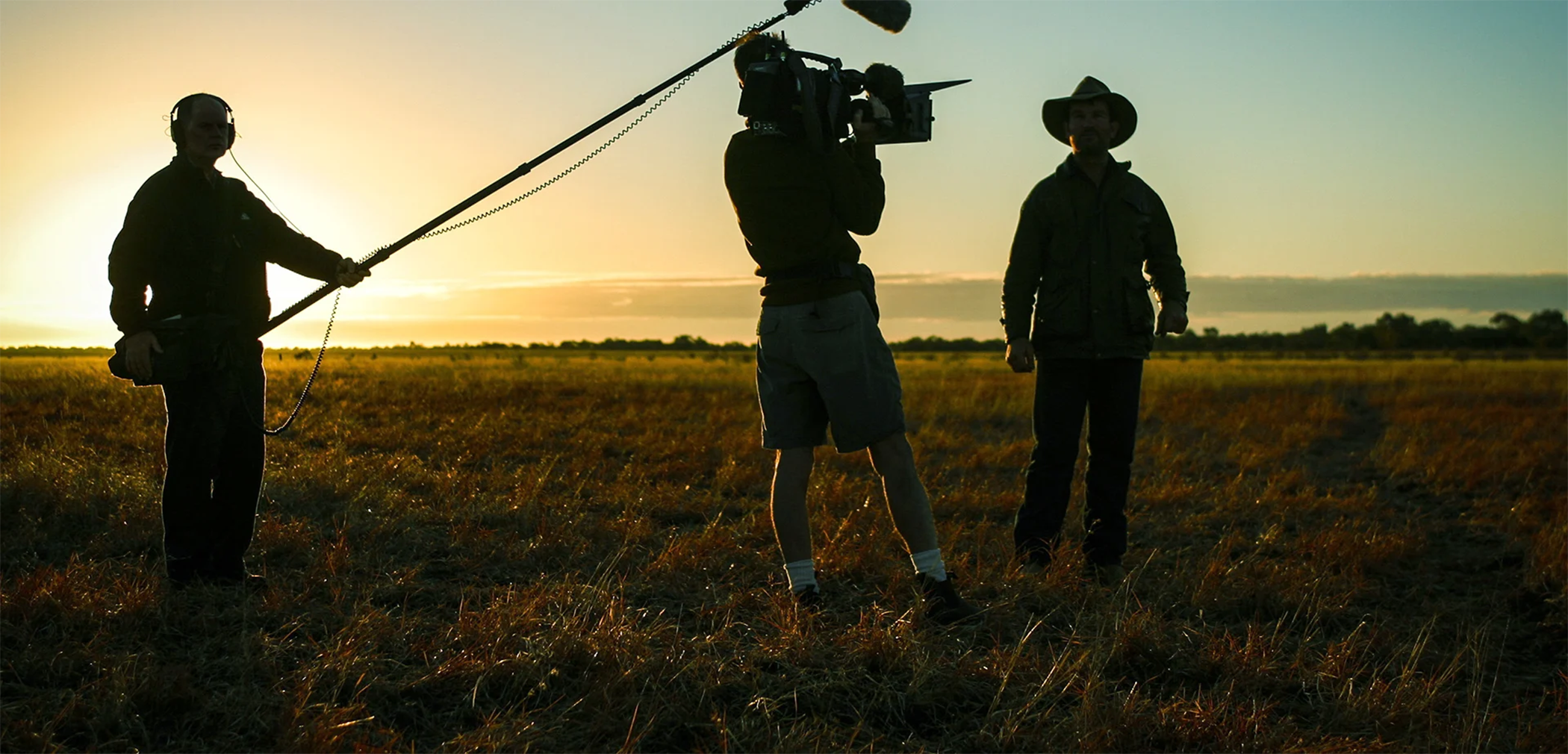 Film crew on location in a field at dusk