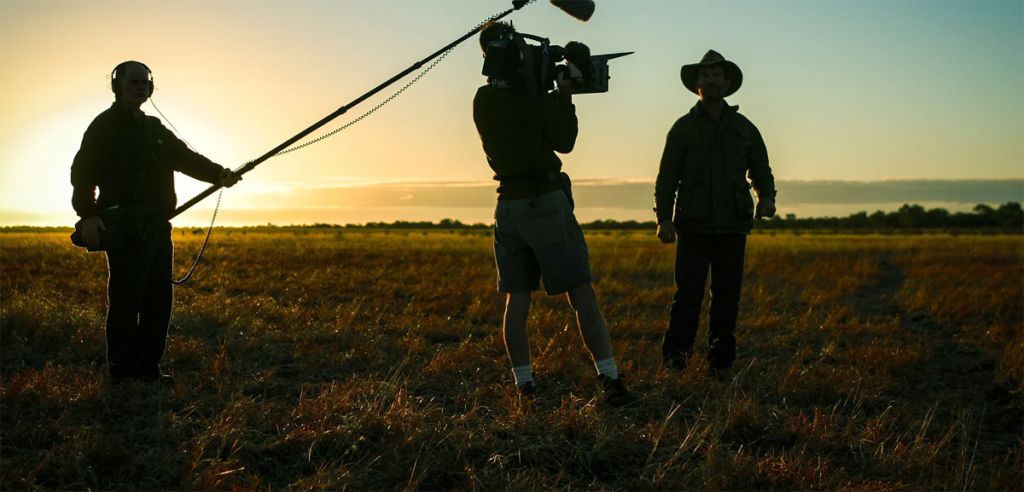 A film crew at dusk to illustrate do you need a degree to be a cinematographer.